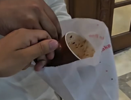 (Two guys making a prank video with a McDonald's cafe cup.)