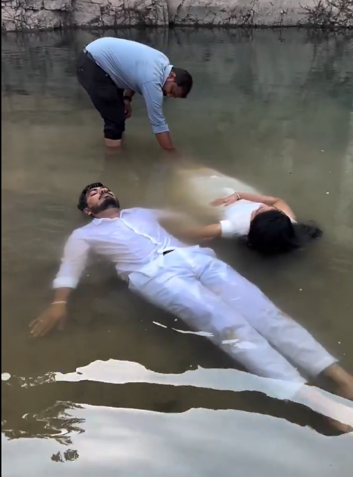 कीचड़ में लेटे कपल का वायरल प्री-वेडिंग फोटोशूट वीडियो स्क्रीनशॉट।